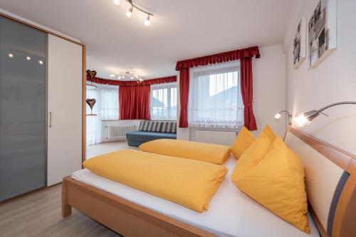 1 dormitorio con 2 almohadas amarillas en una cama en Residence Tauber, en Valles