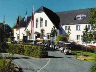 a large white house with cars parked in front of it at Golfhotel Fahrenbach in Tröstau