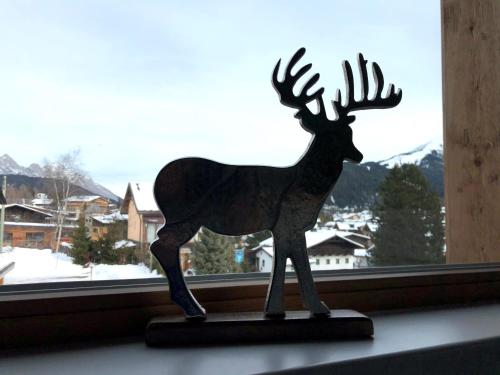 a statue of a reindeer sitting in a window at Chalet Bergzeit in Seefeld in Tirol