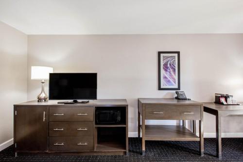 a hotel room with a television and a desk at La Quinta by Wyndham Pomona in Pomona