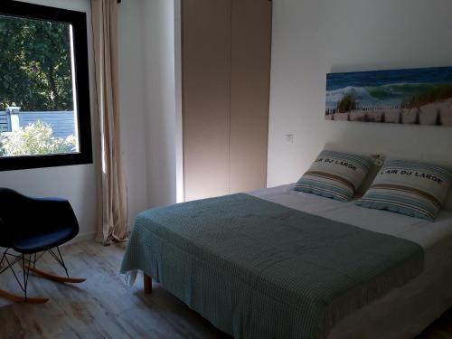 Schlafzimmer mit einem Bett, einem Fenster und einem Stuhl in der Unterkunft Villa de Gascogne in Lanton