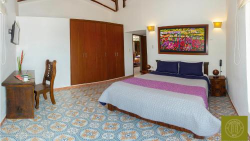 a bedroom with a large bed and a wooden cabinet at Finca del Café - Casa Typica in Santa Rosa de Cabal