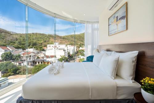 a bedroom with a large bed with a large window at Aquatel Vung Tau in Vung Tau
