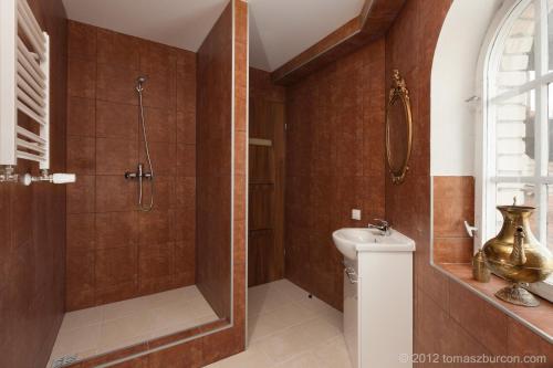 a bathroom with a shower and a toilet and a sink at Hotelik Bach in Gdańsk