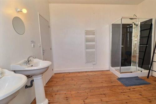 Un baño con lavabo y ducha de cristal. en Maison de famille Penmarch, en Penmarch