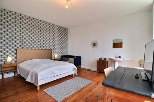 Un dormitorio con cama, escritorio y televisión. en Maison de famille Penmarch, en Penmarch