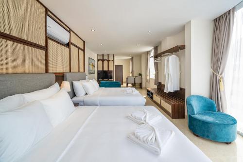 a hotel room with two beds and a chair at Aquatel Vung Tau in Vung Tau