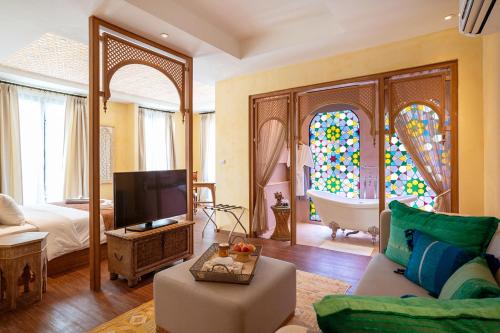 a living room with a tv and a bathroom with a tub at The Ryad Rayong in Mae Pim