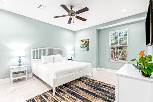 1 dormitorio con cama blanca y ventilador de techo en Crystal Beach Townhomes, en Destin