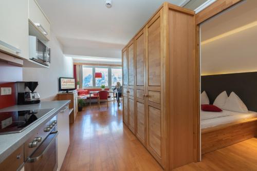 a kitchen with a large wooden cabinet with a bed in it at Nassfeldhaus in Sonnenalpe Nassfeld