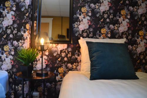 a bedroom with a bed and a wall with flowers at Hotel Restaurant Cafe Houben in Nunhem