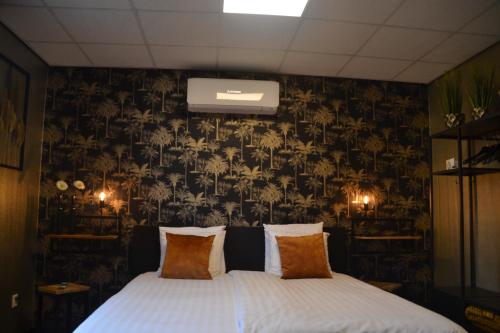 a bedroom with a bed with a floral wallpaper at Hotel Restaurant Cafe Houben in Nunhem