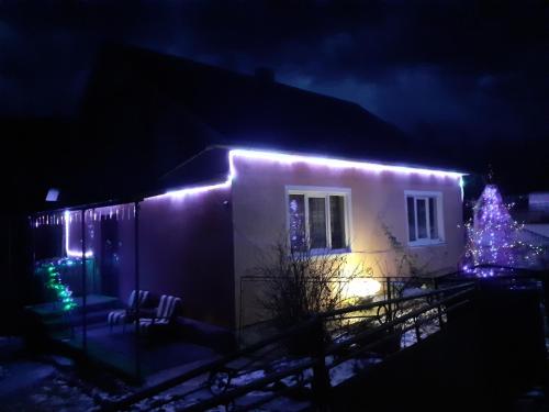 a house with christmas lights on it at night at Gostynnyi Dvir u Marichky in Lazeshchyna