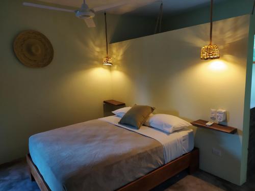 
a bedroom with a bed and a lamp at Residencia El Balatà in Las Terrenas
