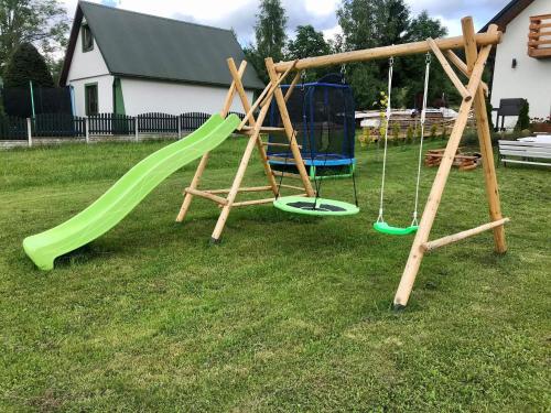 a playground with two swings in a yard at Orawski Letniskowiec in Zubrzyca Dolna