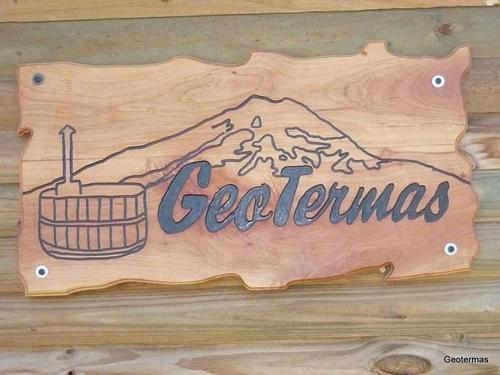 a sign on a wooden wall with a mountain at Geotermas Spa de Montaña in Antuco