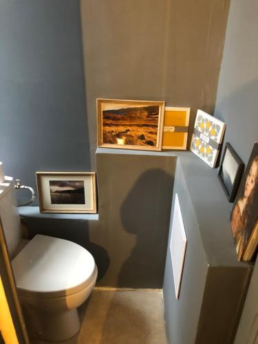 オー・ボンヌにあるAppartement Joséphineのバスルーム(トイレ付)が備わります。壁に絵が飾られています。
