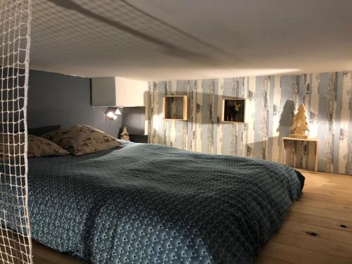 a bedroom with a bed with a blue comforter at Appartement Joséphine in Eaux-Bonnes