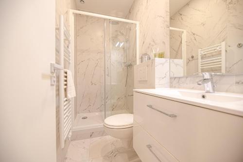een badkamer met een toilet, een wastafel en een douche bij Cosy home in Paris Center - With AC in Parijs