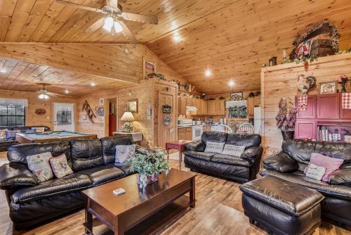 una sala de estar con muebles de cuero en una cabaña en Inspiration Point Cabin, en Sevierville