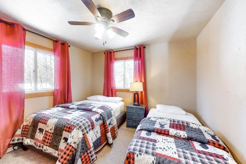 a bedroom with two beds and a ceiling fan at High Lake Hideaway in Boulder Junction