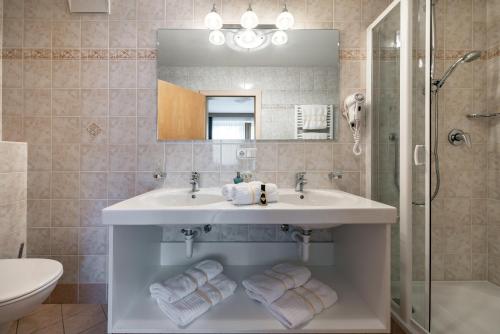 a bathroom with a sink and a shower and a mirror at Residence Tauber in Valles