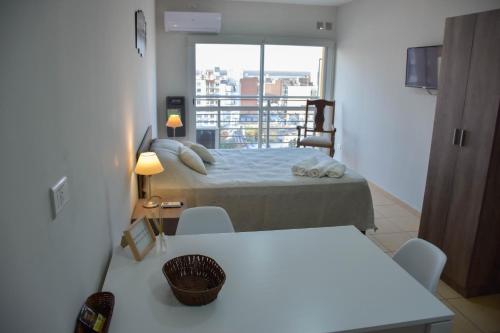 巴拉那的住宿－AP138 8b Departamento micro Centro Paraná，一间卧室配有一张床铺和一张桌子,并设有一个阳台