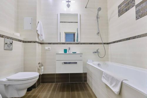 a bathroom with a toilet and a sink and a tub at Апартаменты Петровские однокомнатные Трифонова 22 in Tomsk