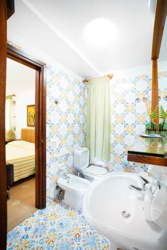 a bathroom with a white sink and a toilet at Residence del Sole in Lampedusa