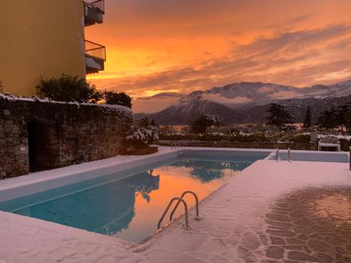 a swimming pool with a sunset in the background at Casa Angelo in Malcesine