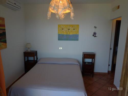 a bedroom with a bed and a chandelier at Bed & Breakfast Laino in Maratea
