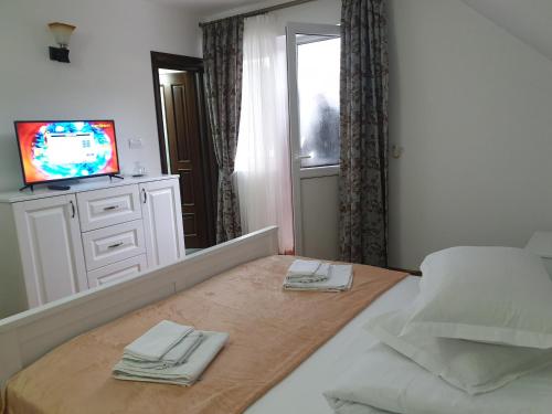 a bedroom with a bed with two towels on it at Pensiunea Putnisoara in Putnişoara