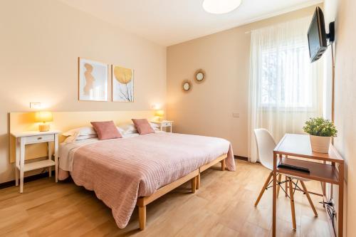 a bedroom with a bed and a desk and a television at Agriturismo il Bio Nonno in Cento