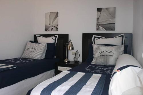 2 Betten in einem Schlafzimmer mit blau und weiß in der Unterkunft Villa Gala in Cala'n Bosch