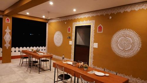 a dining room with tables and chairs and a wall with a mirror at Ranthambhore Tiger Valley in Sawāi Mādhopur