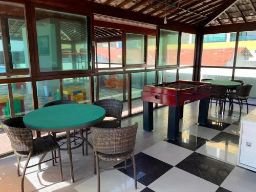 a room with a ping pong table and chairs and a pool table at Tabatinga Residence Flat Pé na Areia I in Conde
