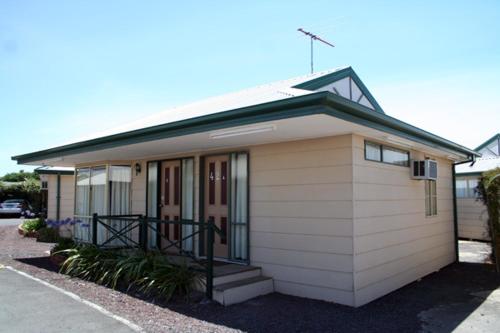 a small house with a porch and stairs to it at West City Motel in Ardeer