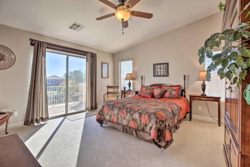 a bedroom with a bed and a large window at Sunny San Tan Valley Home with Grill on Golf Course! in Magma
