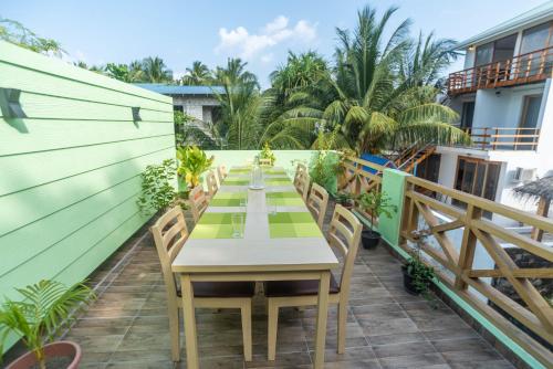 a table on the balcony of a house at Turtle Maldives - Your Gateway to the Beach & Marine Adventures Await! in Omadhoo