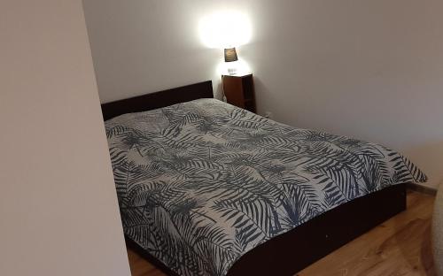 een bed met een zwart-wit dekbed in een slaapkamer bij Apartament OLIVER in Świnoujście