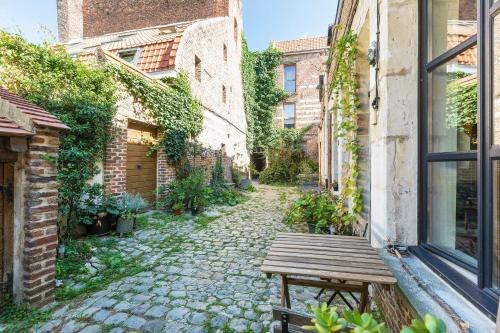 une allée avec un banc en bois et une fenêtre dans l'établissement La Corderie, à Lille
