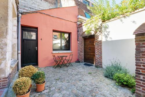 une maison avec une porte noire et une terrasse dans l'établissement La Corderie, à Lille
