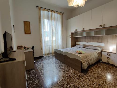 sypialnia z dużym łóżkiem i telewizorem w obiekcie Wow Home - 175 mq - posteggio privato - davanti porto traghetti - fino a 10 posti letto w Genui