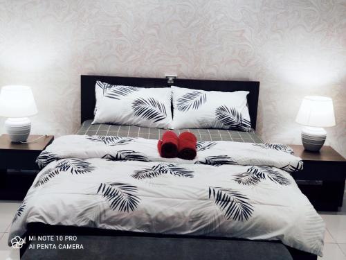 a bedroom with a bed with two lamps and red shoes at Kumkum Homestay Studio in Nusajaya