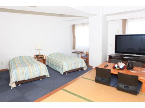 een kamer met 2 bedden en een flatscreen-tv bij Hotel Kokusai Plaza - Vacation STAY 09930v in Naha