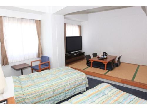 een hotelkamer met een bed en een televisie bij Hotel Kokusai Plaza - Vacation STAY 09930v in Naha