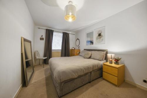 a bedroom with a bed and a table and a mirror at SkyCity London Bridge I Bed Apartment by Tower Bridge in London