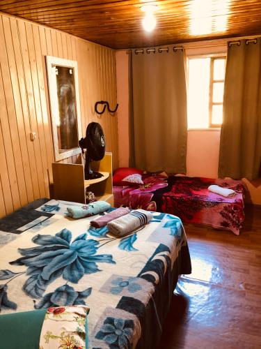 a room with two beds in a room with a window at Casa da Vó Adelina in Urubici
