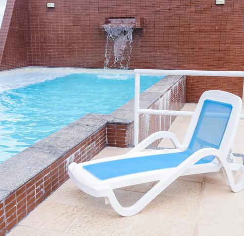 una sedia blu e bianca seduta accanto alla piscina di Executive Hotel a Feira de Santana