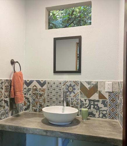 a bathroom with a sink and a mirror at Luz En El Cielo Eco-B&B/Hostel in Montezuma